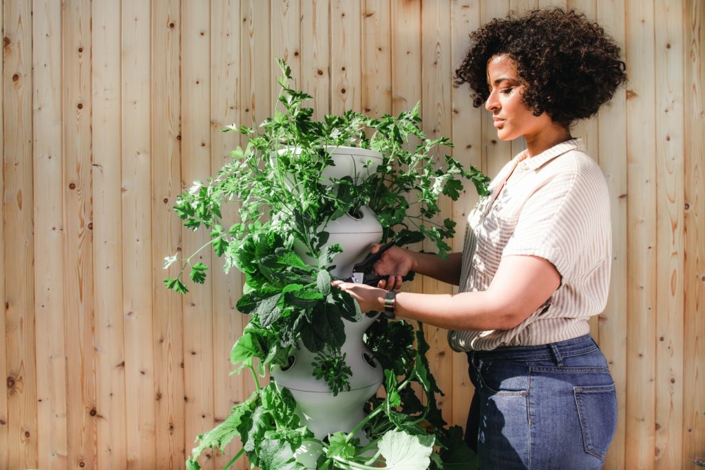 woman standing next to vertical planter