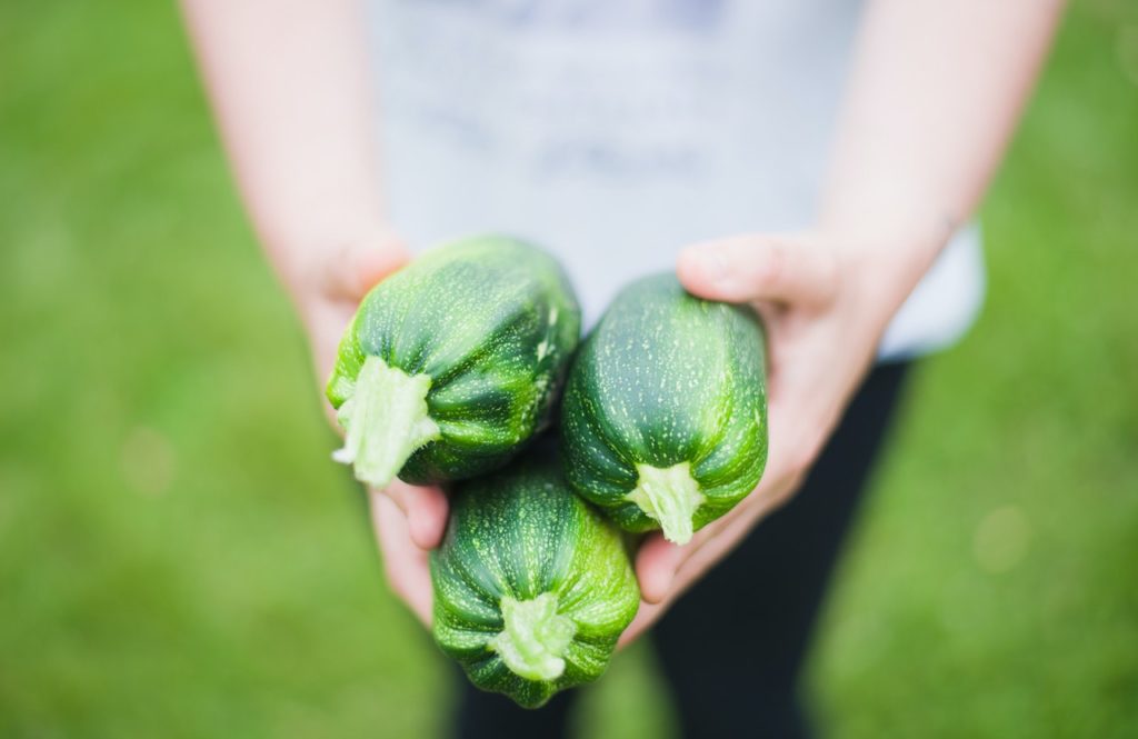 woman holding zucchini